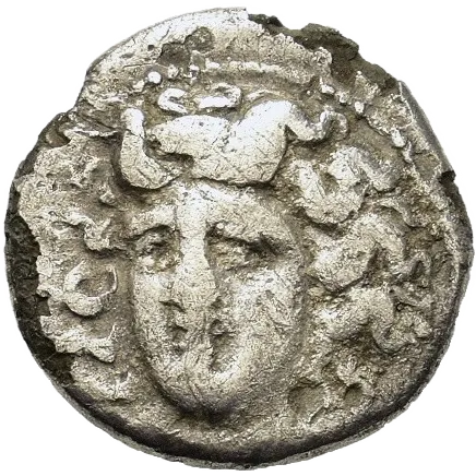 Head of the nymph Larissa facing, turned slightly to the left, wearing ampyx, pendant earring, and simple necklace; within border of dots.